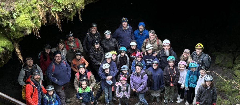 Group of people standing by a cave entrance